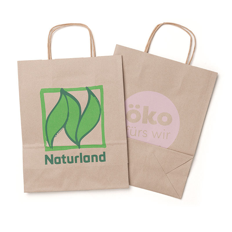 Mittlere braune Papiertüte mit Henkeln, Vorder- und Rückseite vorne mit grünem Naturland-Logo, hinten mit Aufdruck „öko fürs wir“